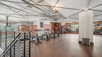 A gym with exercise bikes and a railing.